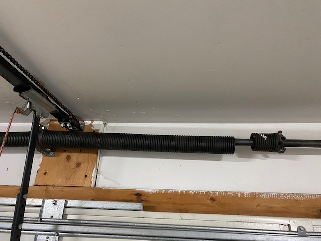 Broken torsion spring with visible coil gap on a residential garage door in Atlanta GA